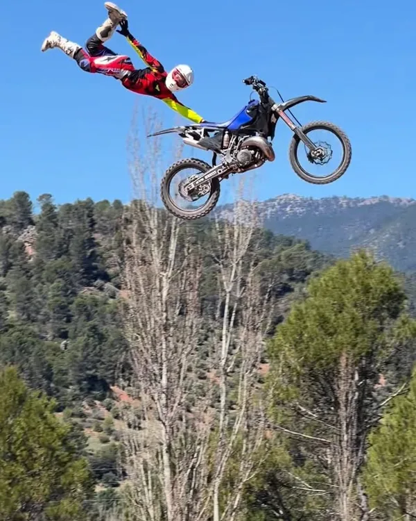 Kevin Sánchez saltando con su moto sobre un bosque