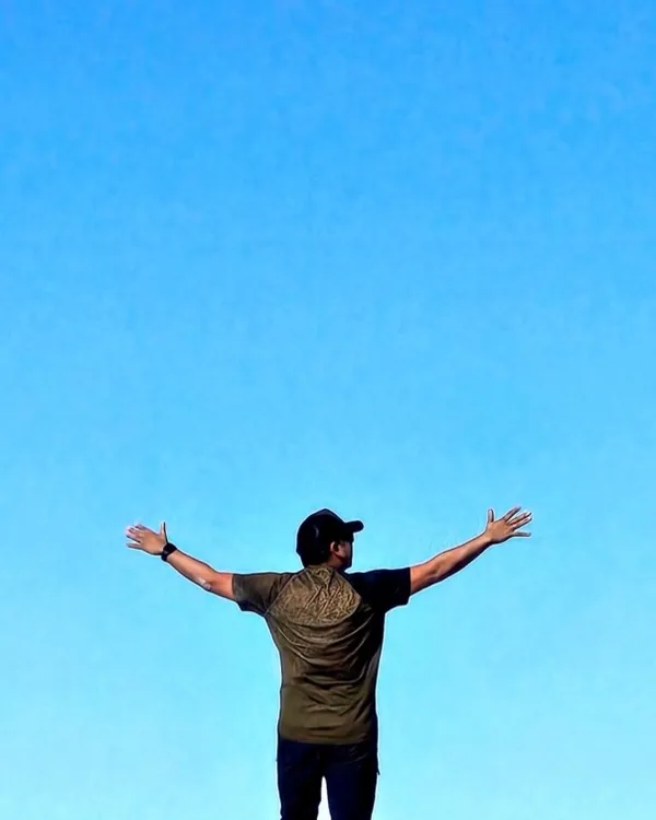 Matias Figari con los brazos abiertos frente al cielo