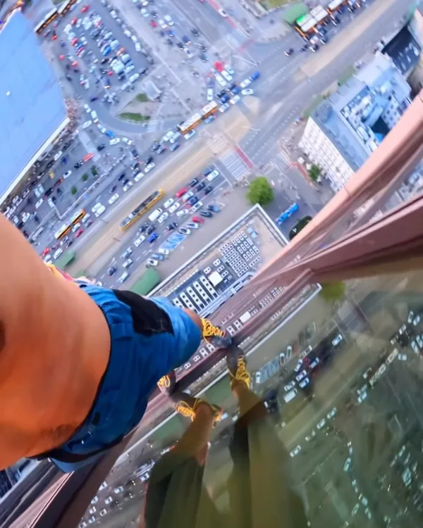 Vista en primera persona escalando un edificio sobre una calle
